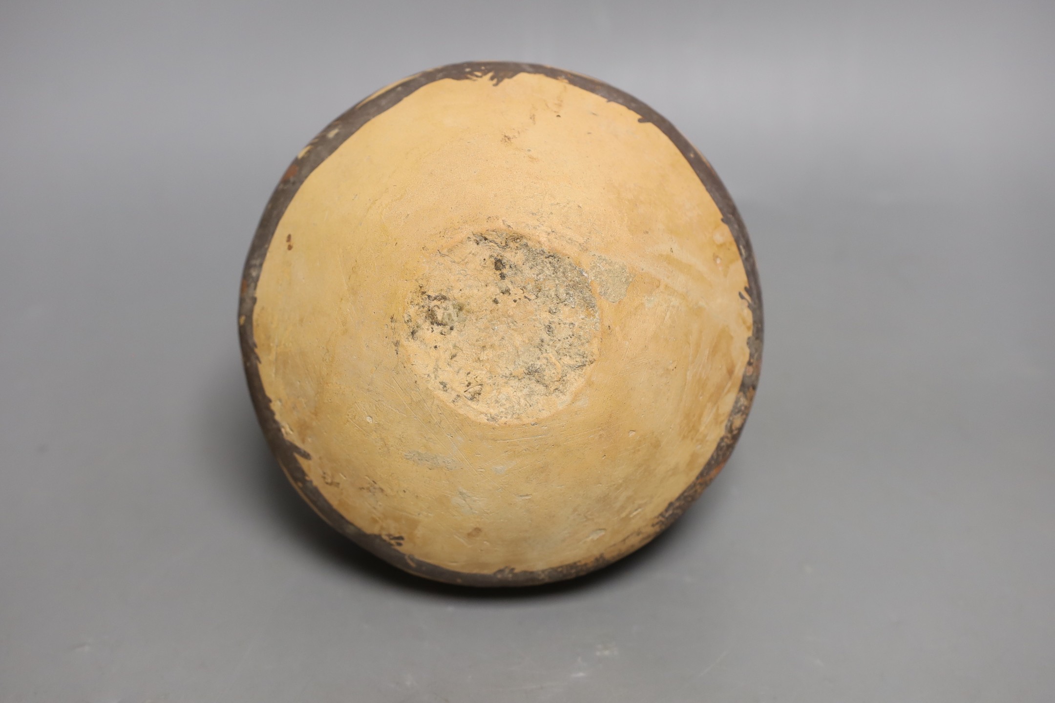 A Chinese pigment painted pottery two handled jar, possibly Neolithic, 14cm high